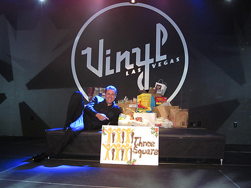 Headliner Mark OToole strikes a pose with donations for Three Square Food Bank